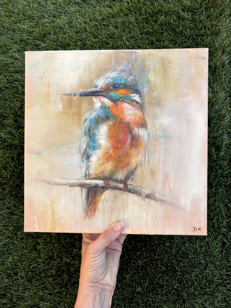 Peinture à l’huile originale représentant un martin-pêcheur aux plumages orange et turquoise sur une branche, sur fond beige et ocre, par Deborah Kerner. Tableau carré de 30 × 30 cm.